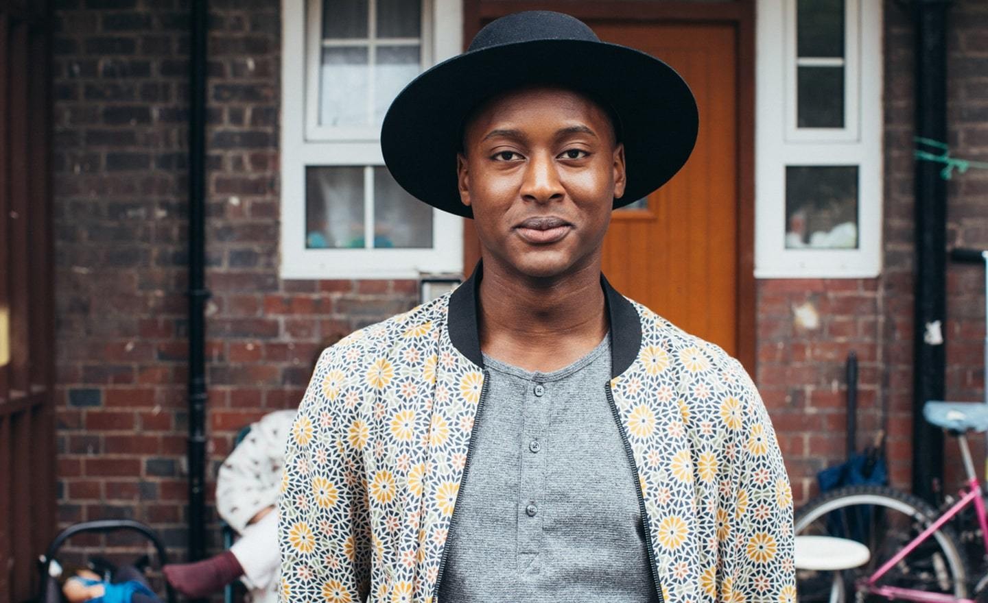 Black man in a hat smiling at camera