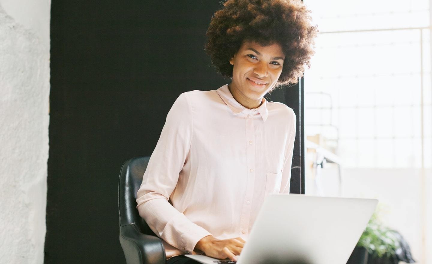 Black woman in chair with laptop