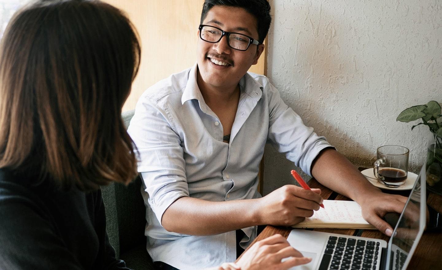 Coworkers meeting at a desk with laptop