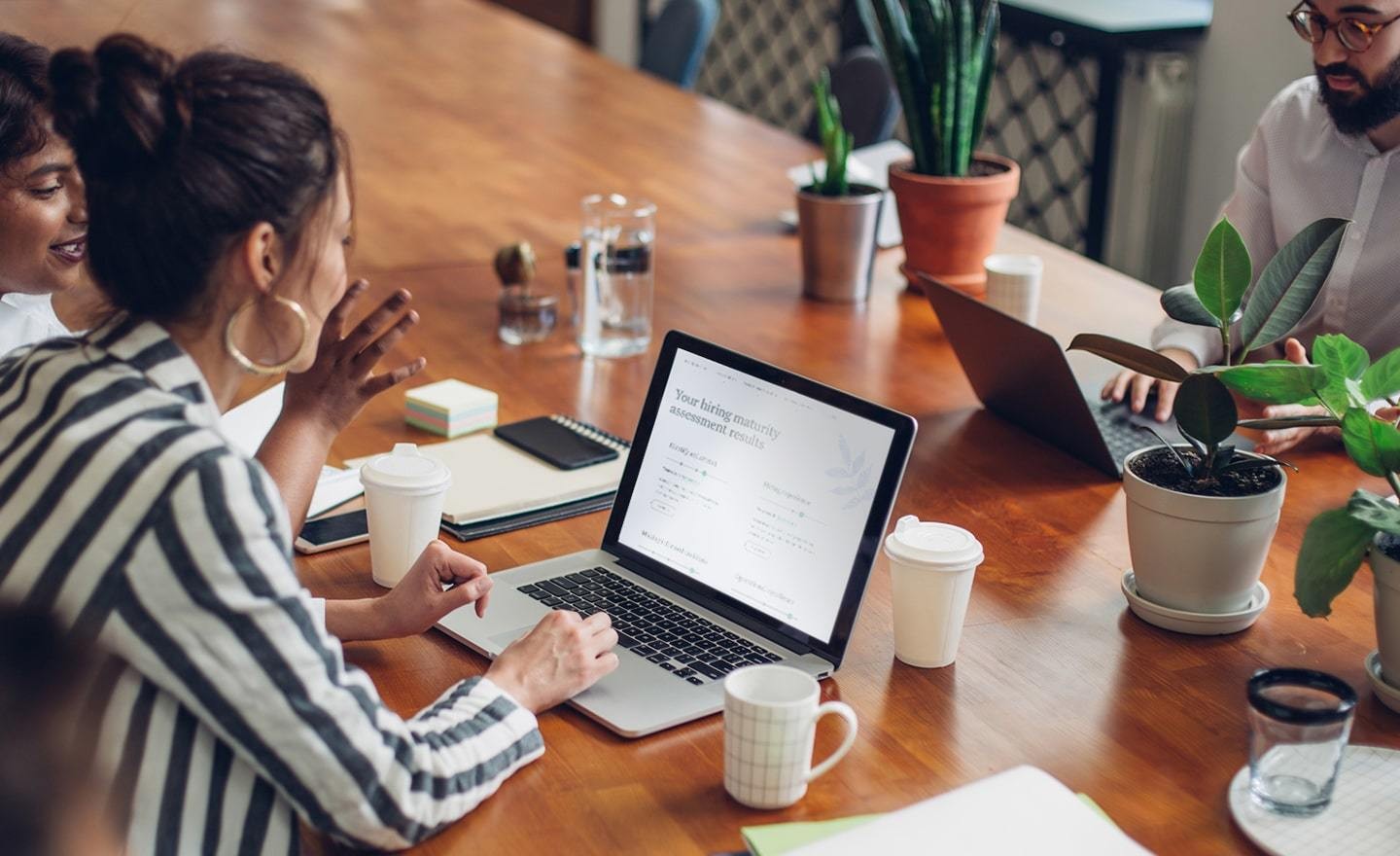 Group of coworkers around a conference table with plants