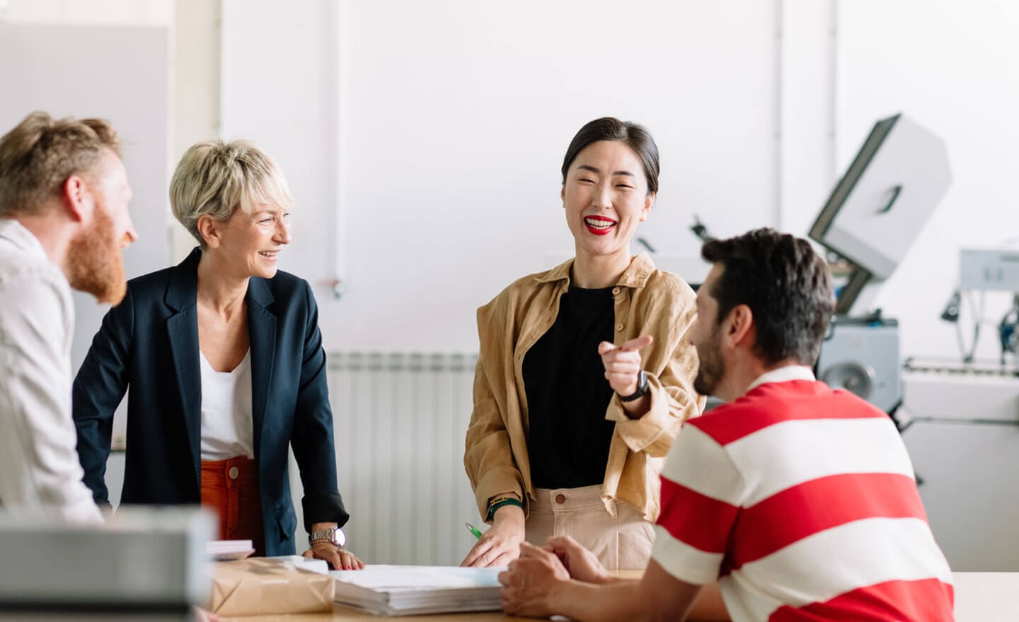 Happy team laughing in office meeting