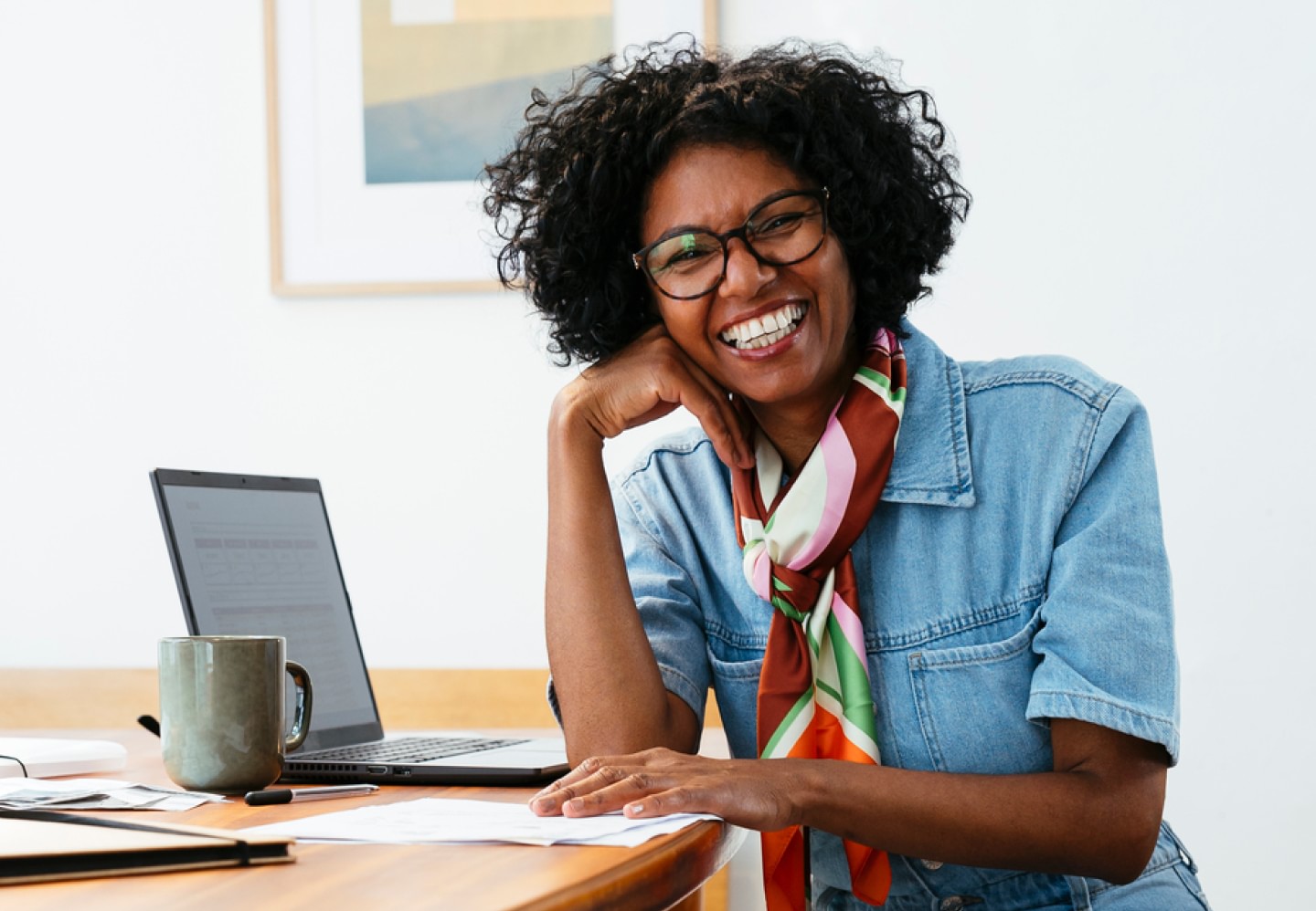 Image of happy woman smiling while working on laptop from home