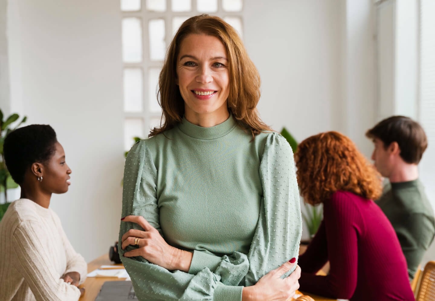 Image of happy woman smiling while working with team