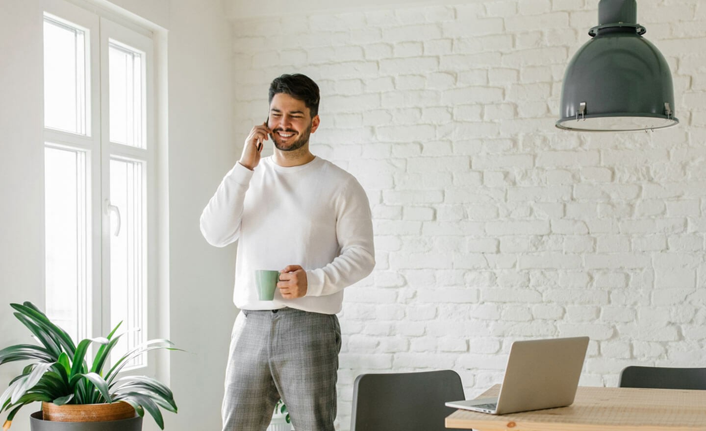 Man on phone in coworking space with sweater