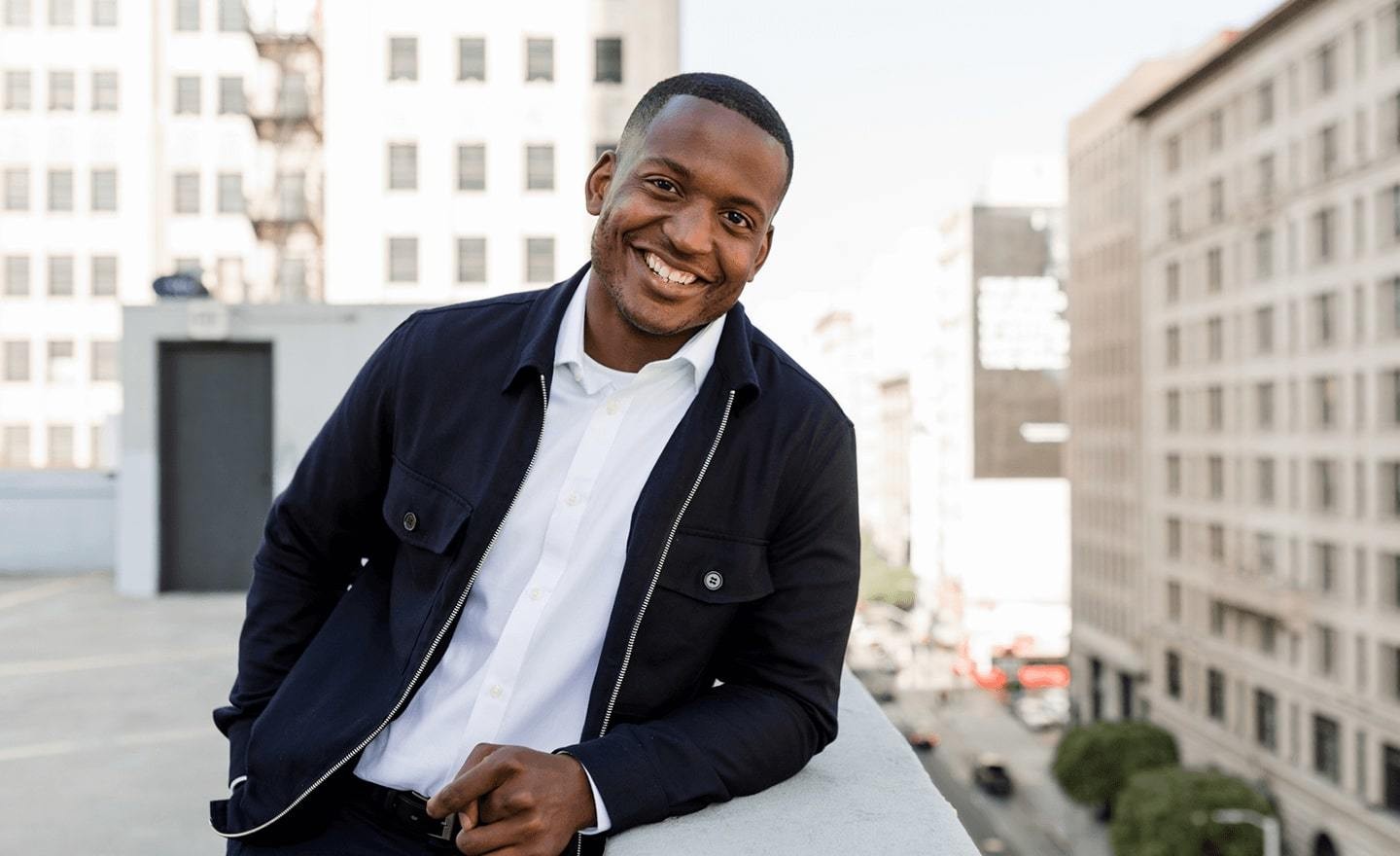 Man outside on rooftop smiling at camera