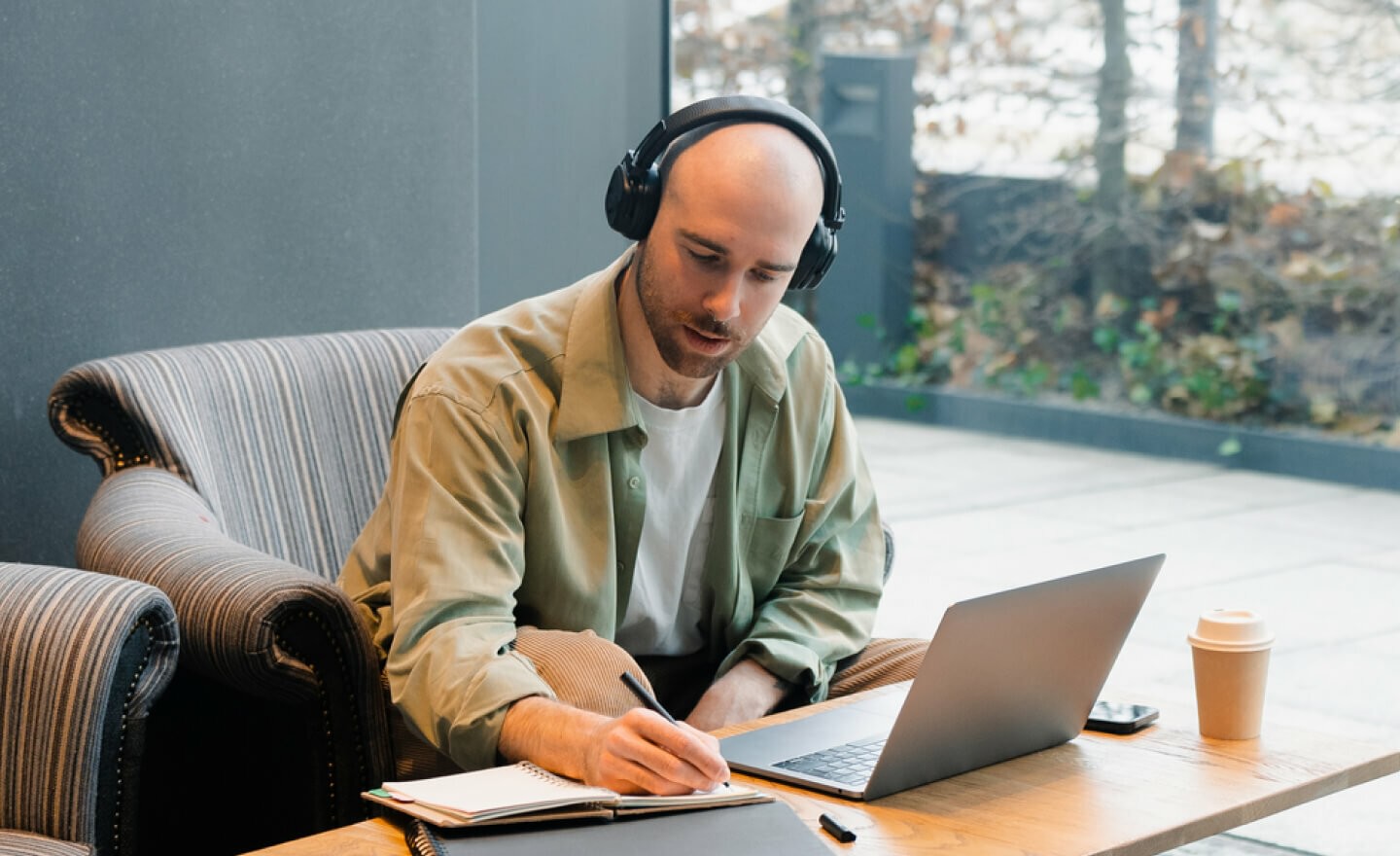 Man wearing headphones working on laptop