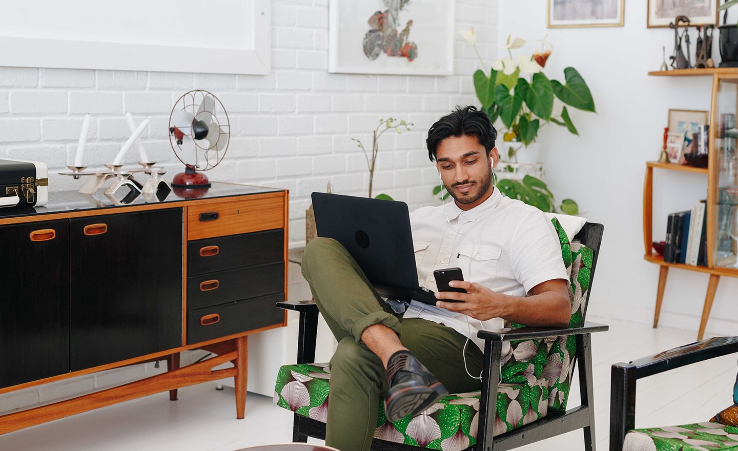 Man working at home on phone and laptop