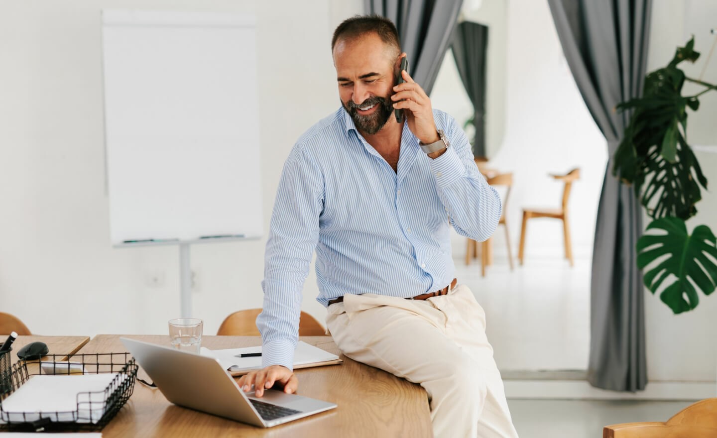 Man working on computer and talking on phone