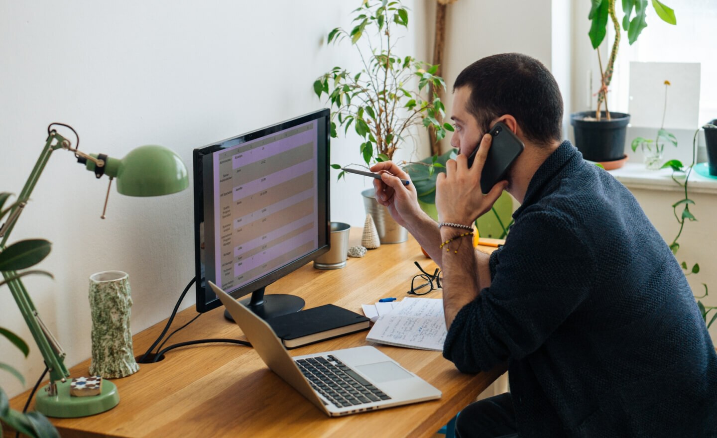 Person on phone computer and spreadsheet 720x440