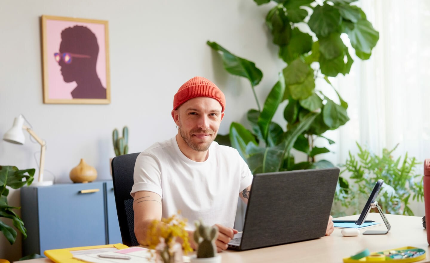 Person with beanie at desk working on laptop 720x440