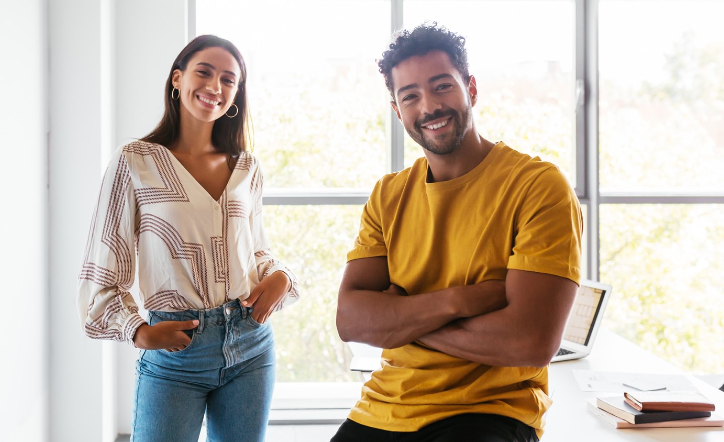 Two coworkers standing in front of a window