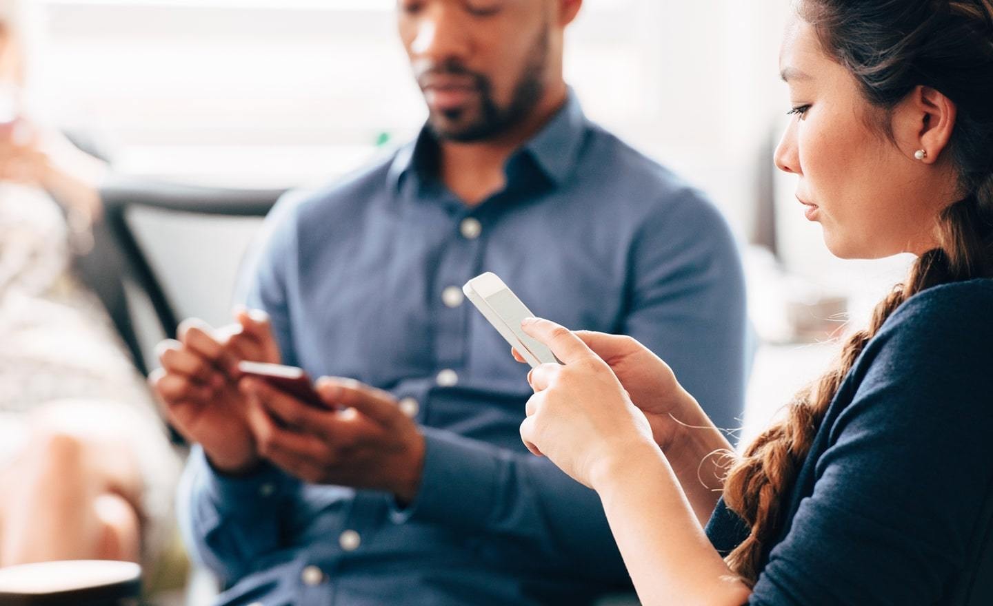 Two people using their smart phones