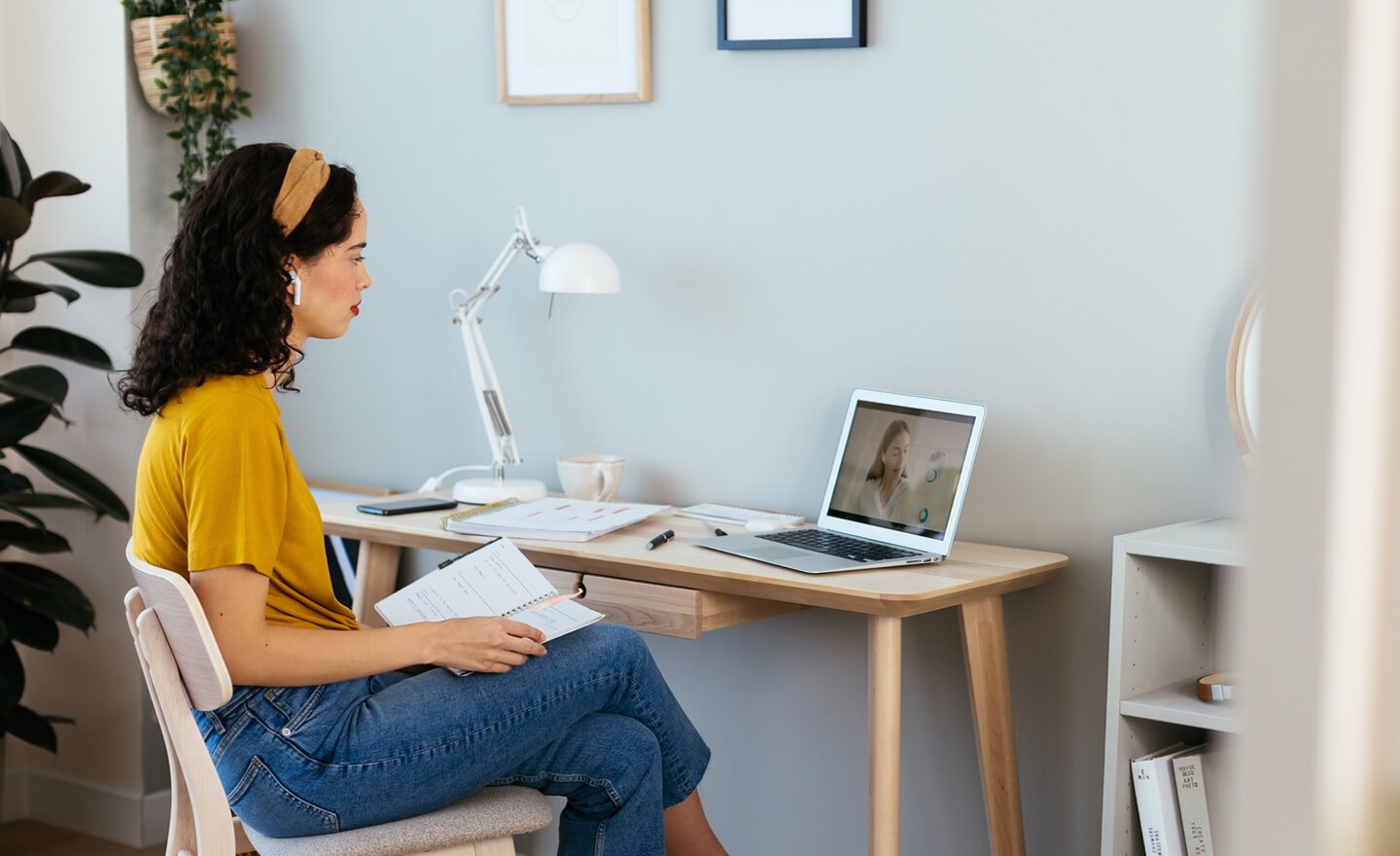 Woman watching virtual conference on laptop