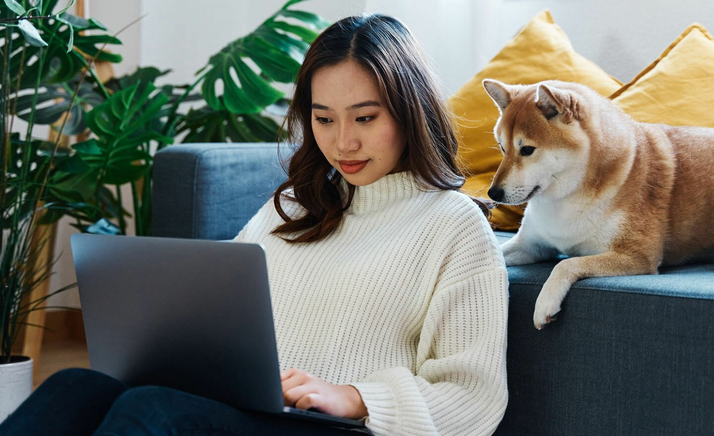 Woman working on laptop with dog 1