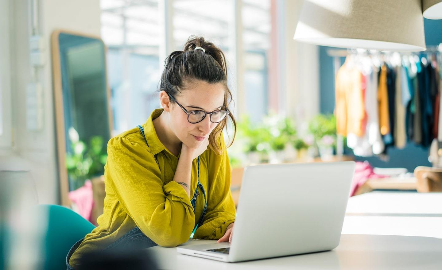 Young woman in yellow shirt at her laptop