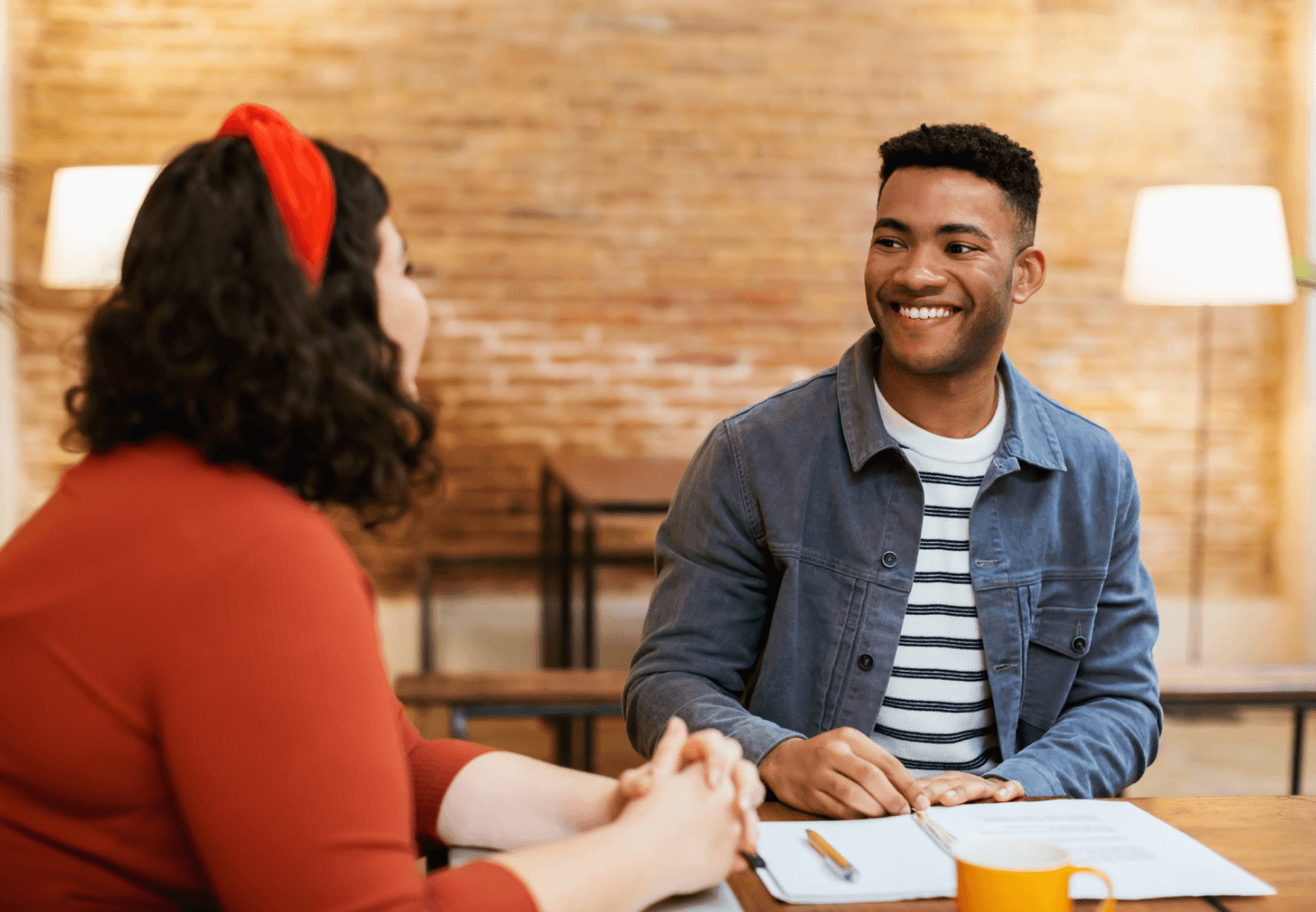 Man smiling while talking with colleague