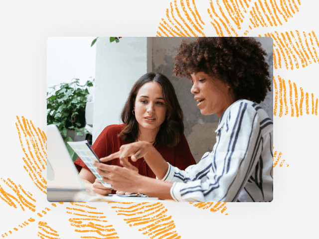 Photo of two woman looking at a document