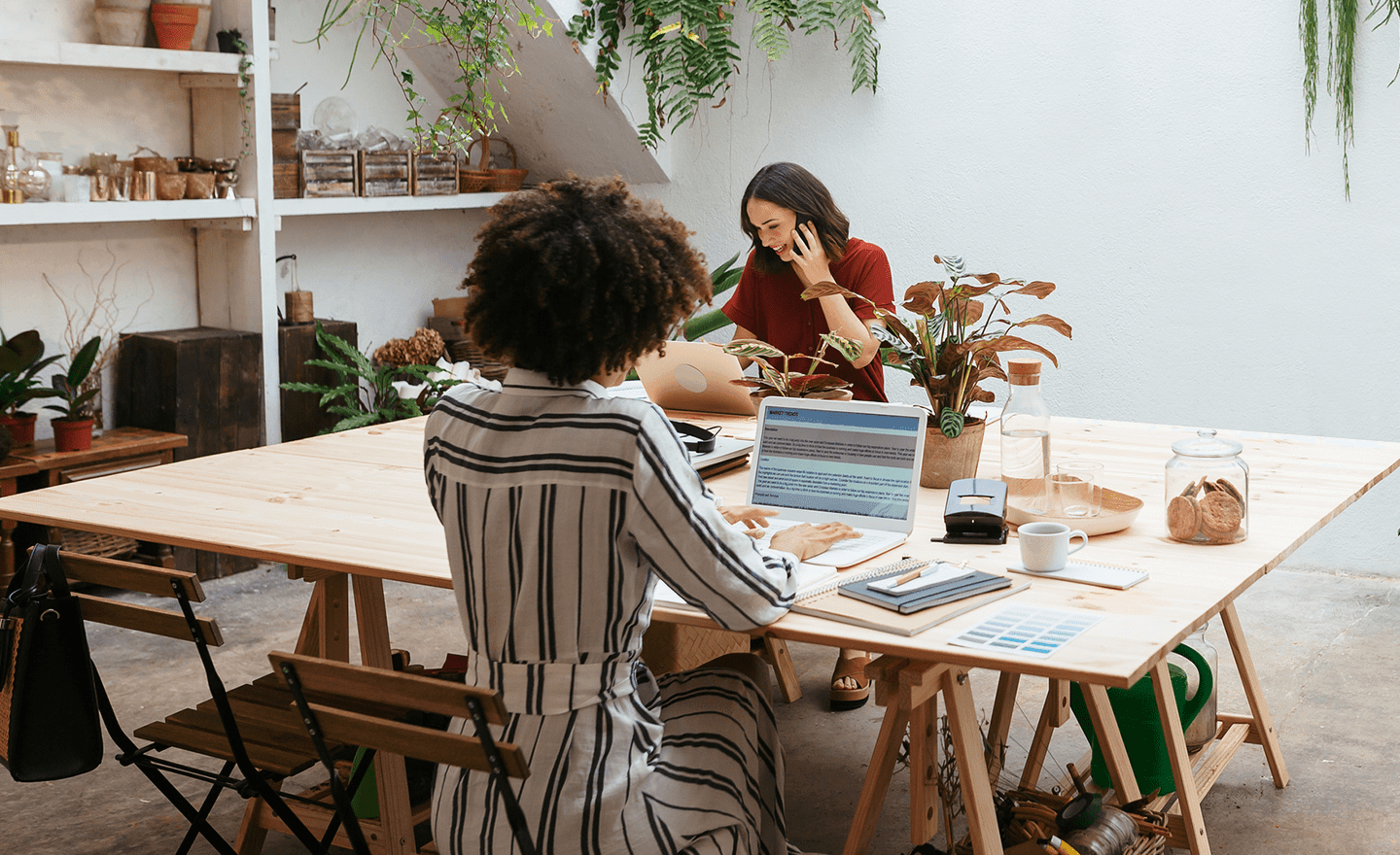 Two women working in plant filled office